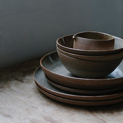 Dark ceramic bowls and plates set by Sue  Paraskeva